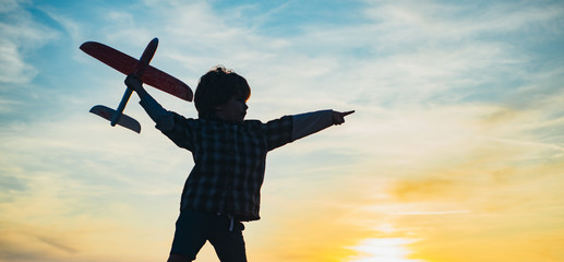 Little aviator over sunset sky. Cherishing memories of childhood. Active children concept. Kid having fun with toy airplane in field.