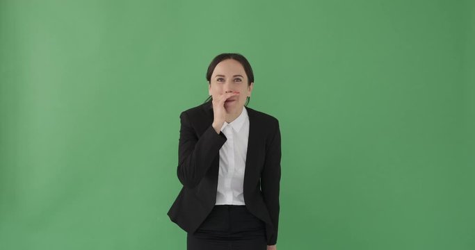 Excited businesswoman whispering message over green background