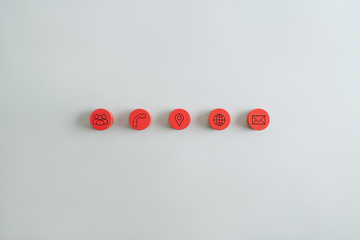 Five red round wooden pieces with contact icons
