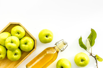 Apple cider in bottle near tray with fruits on white background top view copy space