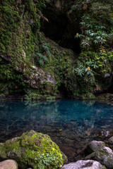 Naklejka na ściany i meble Poco Azul waterfall (blue well) in a subtropical forest with on the bottom an azure blue color pool surrounded by green plants, Achadinha, Nordeste, São Miguel Island, Azores, Portugal