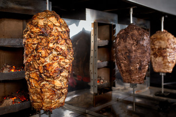 Close up shot of stacked meat roasting to be used in preparation of traditional Greek dish gyros or...