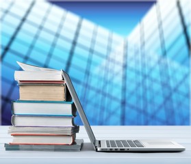 Stack of books with laptop