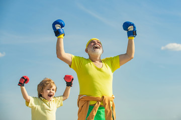 Senior trainer and little boy wearing boxing gloves. Funny cute child fighting. Best cardio workout. Active leisure.
