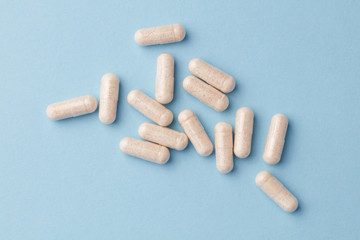 Ginkgo Biloba capsules. Dietary supplements. Bright paper background. Top view. Close up. Copy space. 