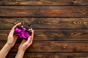 gift in hands on wooden background top view mock up