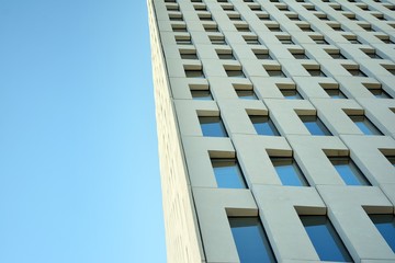 Modern office building detail. Perspective view of geometric angular concrete windows on the facade of a modernist brutalist style building. 