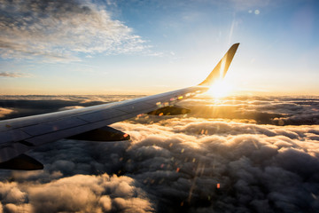 airplane wing view flying above the clouds during sunset, aircraft wing, plane wing