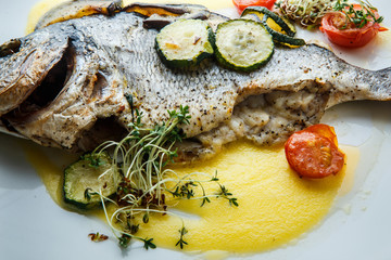 macro delicious fish served with sliced baked vegetables
