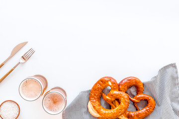 Octoberfest table background. Pretzels and beer glasses on white background top view space for text frame