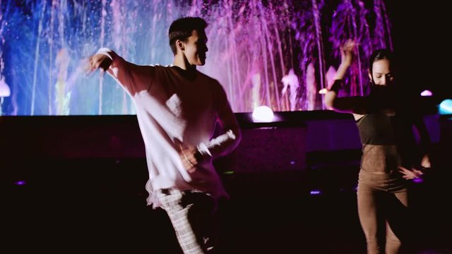 Girl and guy dancing funny looking at the camera. Merry dance. Good emotions.