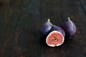 Fresh, juicy, ripe, sweet figs with small bones on a dark wooden background. low key, copy space,...
