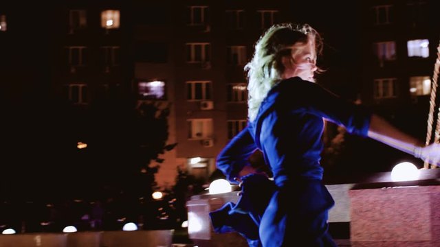 Passionate girl dancing in a blue dress.  Beautiful dance in the night. Very sexy.