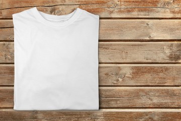 White T-shirt on wooden table top view