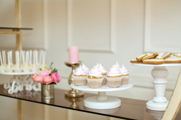 Event table with sweets, minimal decorated with fresh flowers