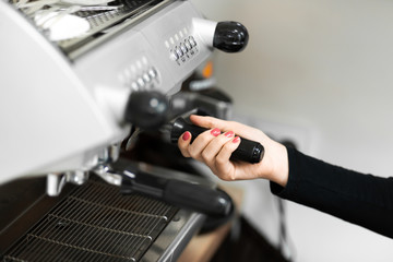 Barista in a coffee shop brews coffee in a coffee machine