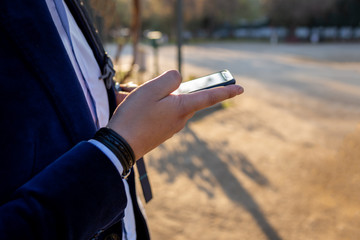 A businessman holding a black cellphone