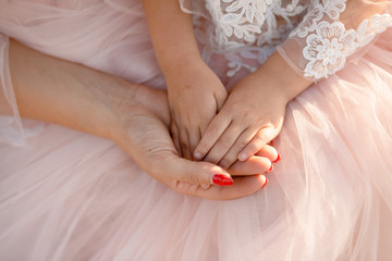 Moms hand holds in her palm the hands of her little daughter