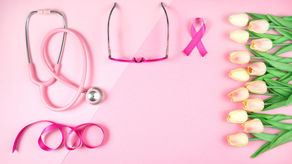 Pink Ribbon Breast Cancer Awareness Month concept flat lay on pink background with copy space.