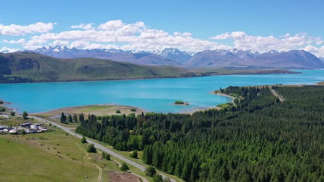 View of lake Tekapo, bushy green forest and Tekapo town, New Zealand