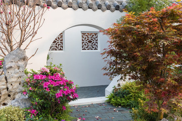 A Moon Gate is a circular opening in a garden wall that acts as a pedestrian passageway, and a...