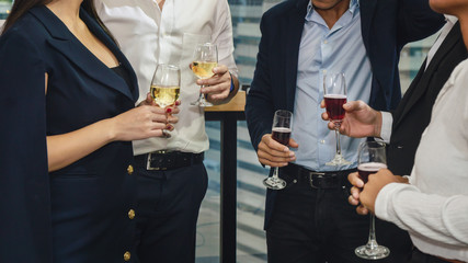 business people with glass of wine and champagne on hands having business discussion in corporate party to celebrate company success