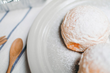 Homemade sweet buns with powdered sugar. Sweet breakfast.Close up view of baker is working.Tasty sweet buns with sweetened condensed milk, Thai tea custard on plate and icing sugar