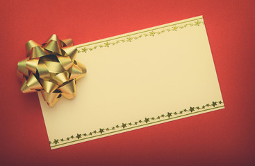 Greeting card on red paper with gold bow