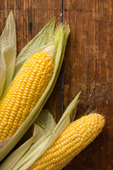 Corn cobs on vintage wood background