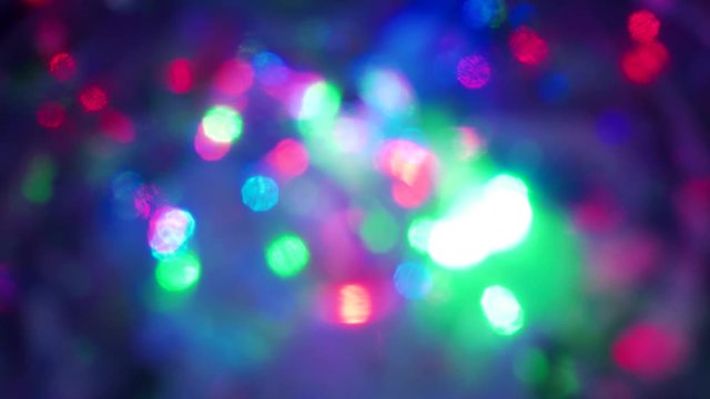 Christmas colorful bokeh with neon lights. Abstract blurred background with blinking pink blue green red flashlights. Flashing color footage 4K