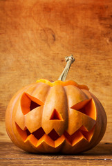 Scary halloween pumpkin on wood background