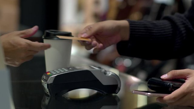 Customer paying by credit card in coffee shop