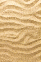 Fototapeta na wymiar Closeup of sand pattern of a beach in the summer day. Nature background.