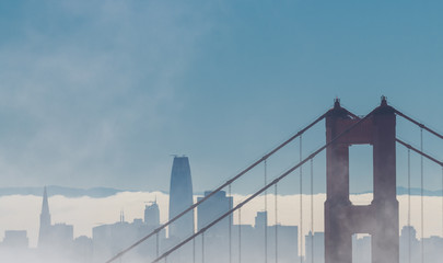 Golden Gate Bridge and the San Francisco skyline under a blanket of fog with plenty of copy space