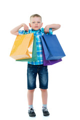 Little boy waving multicolored paper bags. He goes shopping