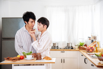 Asian gay couple homosexual cooking together in the kitchen prepare fresh vegetable make organic salad healthy food. Asian people happy time smile, laugh in kitchen. LGBTQ relation lifestyle concept