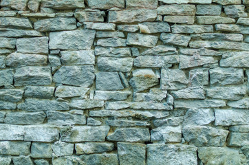 The wall is made of brick and natural stone.