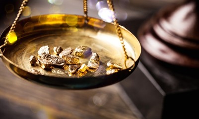 Small gold nuggets in an antique measuring scale