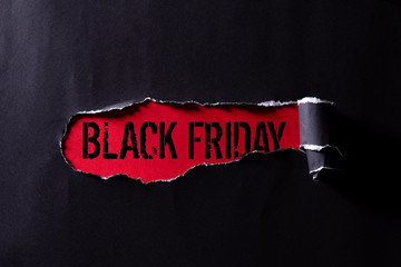 Top view of Black torn paper and the text black friday on a red background. Black Friday composition. - Powered by Adobe