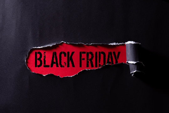 Top view of Black torn paper and the text black friday on a red background. Black Friday composition.