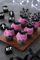 Festive Halloween cupcakes decorated with purple sweet potato fresh cream and black cocoa bat cookies