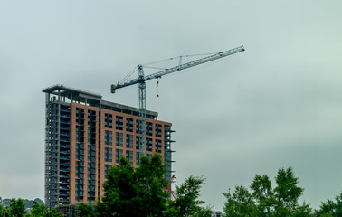Fototapeta premium Blue crane infront of tall building under construction