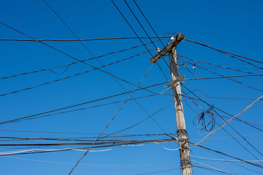 Poteau &eacute;lectrique avec des c&acirc;bles emm&ecirc;l&eacute;s de mani&egrave;re anarchique. Concept de r&eacute;seaux d'&eacute;nergie compliqu&eacute;s ou surcharg&eacute;s et dangereux