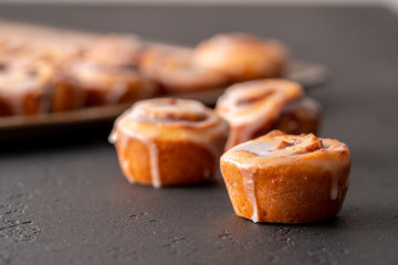 Homemade baked cinnamon rolls baked in a cookie sheet with icing.