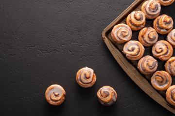 Homemade baked cinnamon rolls baked in a cookie sheet with icing.
