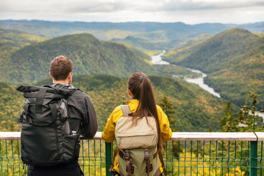 Hike couple camping with backpacks in Quebec National Park in Autumn season, Canada forest travel lifestyle. Tourists looking at view of Jacques Cartier National Park.