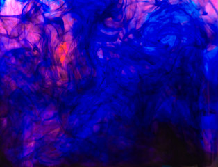 Blurred photo of food color drop and dissolve in water for background and texture concept.