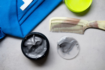 Hair wax and clay in tubs with comb