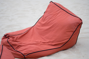 Soft orange bean bag seats to relax on the beach