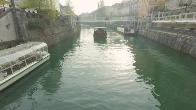 Little touristic boat cruise on its usual route over river Ljubljanica in Ljubljana, Slovenia.